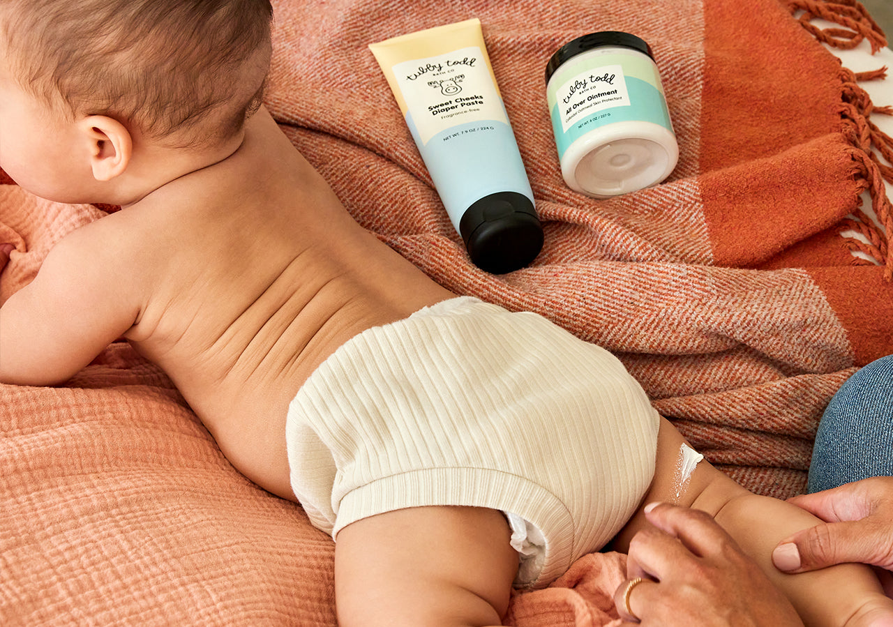 baby lying on stomach with sweet cheeks diaper paste and AOO in background
